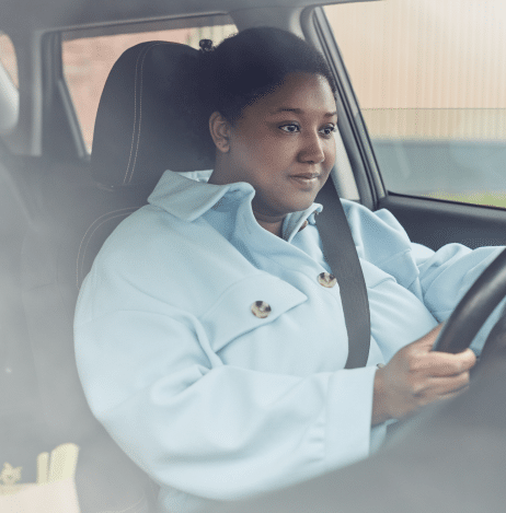 a woman on the driver seat holding her head with both hands